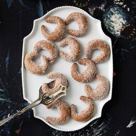 Dekorierte Nougatkipferl mit Schokoladenglasur und Krokant