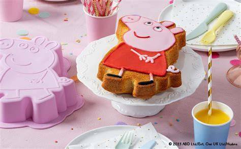 Dekorierte Peppa Wutz Plätzchen zusammen mit Muffins auf dem Kindergeburtstagstisch