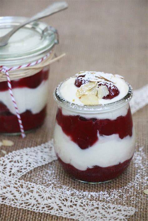 Dessert im Glas geschichtet mit frischen Kirschen und Sahne