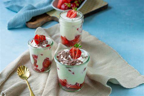 Dessertgläser mit Pudding, frischen Erdbeeren und Minze