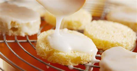 Detailansicht: Zitronen-Zuckerguss, der glänzend auf Muffins verteilt wird