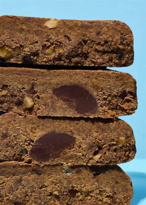Detailaufnahme: Aufgeschnittener Cookie mit sichtbaren Schokoladenstücken und Nüssen