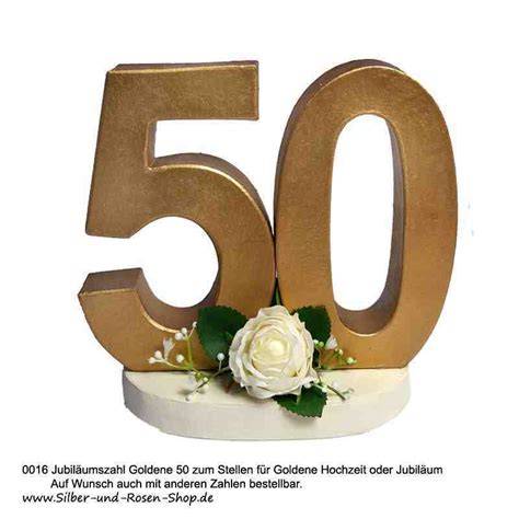 Detailaufnahme: Goldene Dekoelemente, Rosen und „50“ auf einer Goldhochzeitstorte