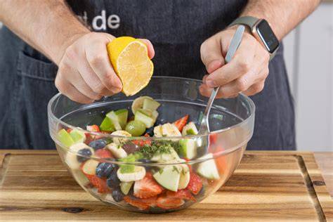 Detailaufnahme: Honig wird über Obstsalat gegeben