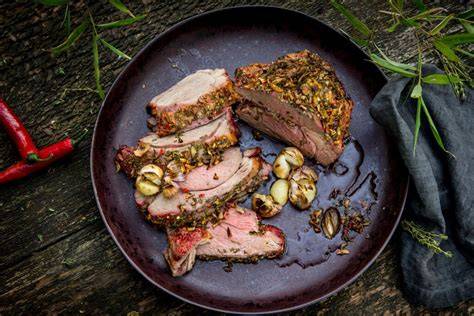 Detailaufnahme: Honig-Glasur, Thymian und Mandelblättchen auf Lammkeule