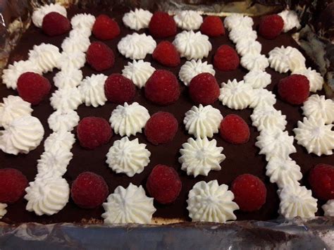 Detailaufnahme: Sahnetuffs, Keksdekor und frische Himbeeren auf Weihnachtsdesserts
