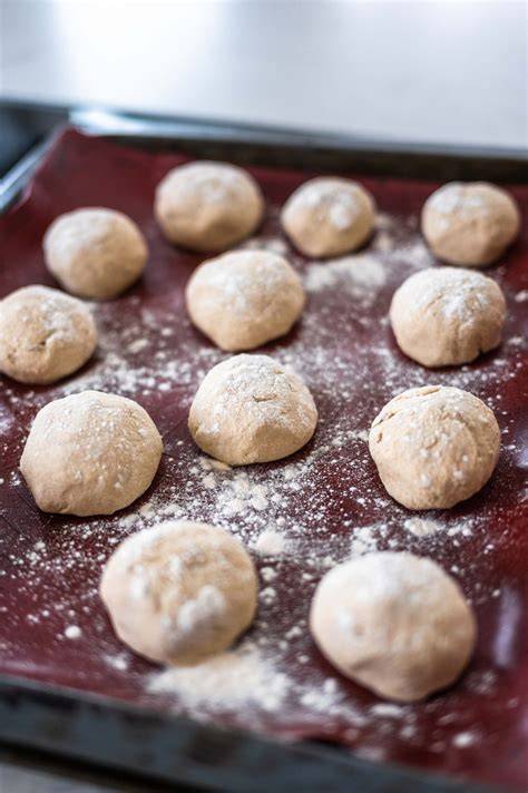 Detailaufnahme: Teig mit Körnern und Cranberries, geformte Kugeln vor dem Flachdrücken
