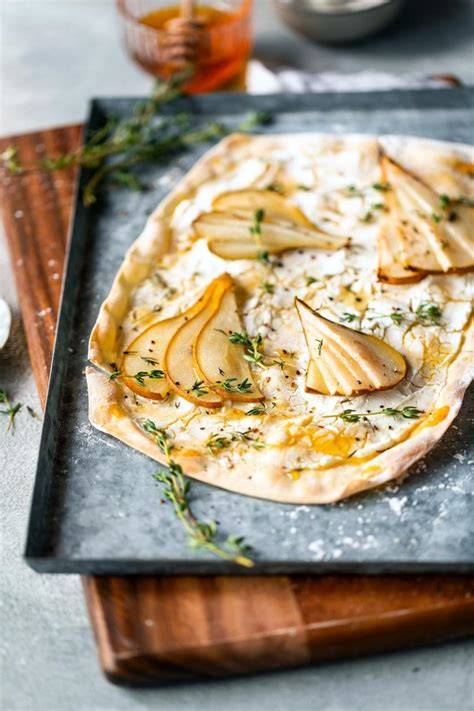 Detailaufnahme: geschmolzener Ziegenkäse auf goldbraunen Birnenspalten