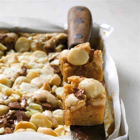 Detailaufnahme: goldbraune Blondies mit Macadamianüssen