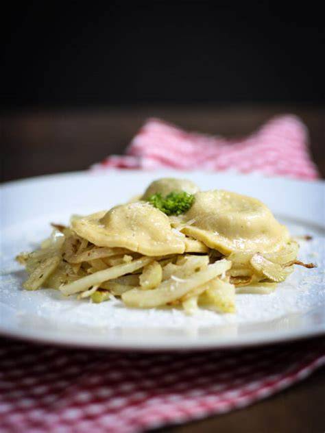 Detailaufnahme eines Ravioli-Tellers mit Trüffel und Brühe