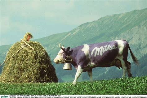 Die lila Kuh in Alpenlandschaft