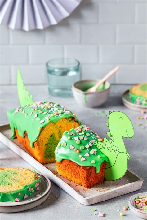 Dino-Kuchen mit grüner Zuckerglasur und Schokolinsen dekoriert