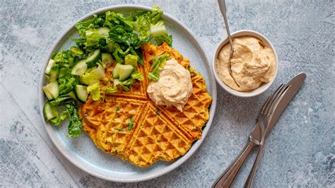 Dip in einer Schale neben Waffeln und Salat