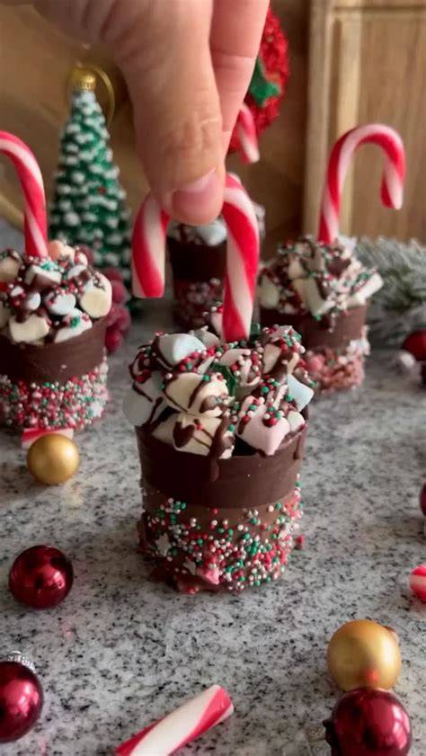 Dreifarbige Schokolöffel in Schnapsgläsern mit Marshmallows obenauf