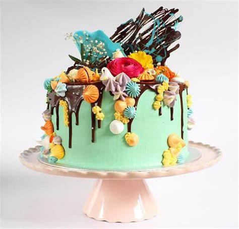 Drip Cake mit verschiedenen bunten Tropfen auf weißem Fondant
