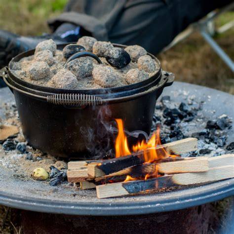 Dutch Oven im Grill mit Briketts auf dem Deckel