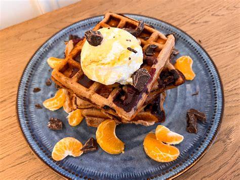 Ein Teller mit einem Stück Waffelkuchen und Mandarinen