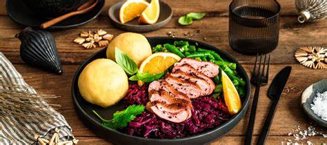 Ein festlich angerichteter Weihnachtsteller mit klassischem Rotkohl, Braten und Klößen