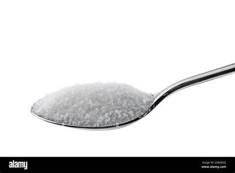 Ein mit Zucker gefüllter Teelöffel neben Zucker in verschiedenen Formen
