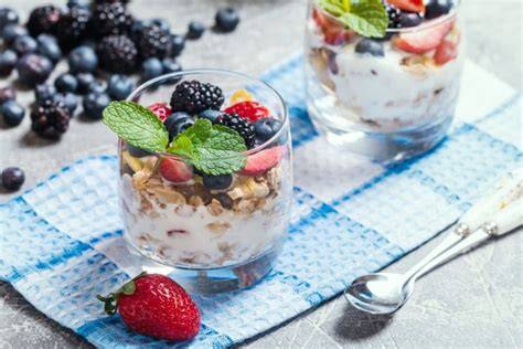 Ein stilvoll angerichtetes Dessertglas mit Schichten aus Joghurt, Müsli und Beeren