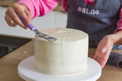 Eindecken der Torte mit weißem Fondant, glatt gestrichen