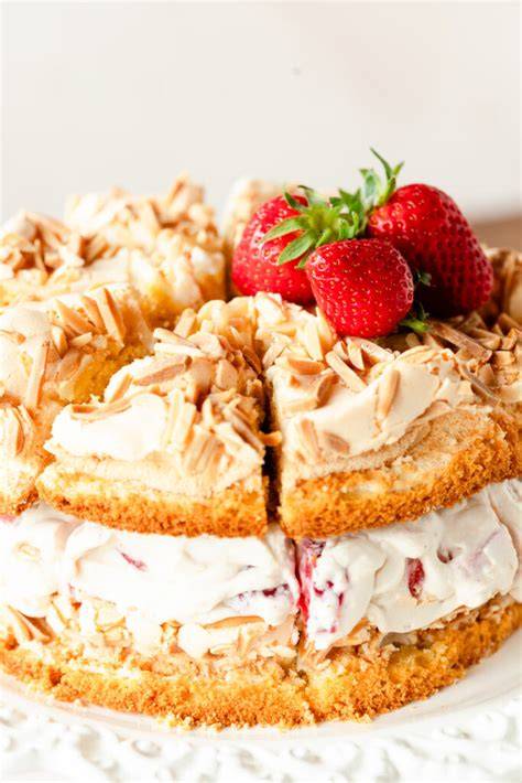 Eine angeschnittene Schwimmbadtorte mit Erdbeeren auf einer Kaffeetafel