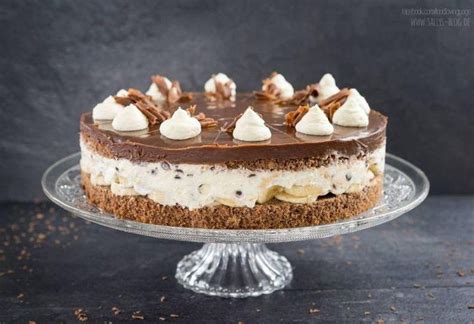 Eine angeschnittene Stracciatella-Bananen-Torte mit dekorativem Schokoladenspiegel