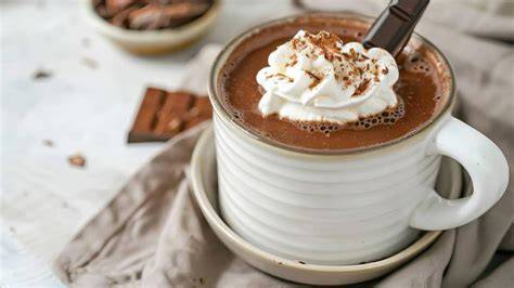 Eine stilvolle Tasse Chocolat Chaud mit Vanilleschote und Zimtstange
