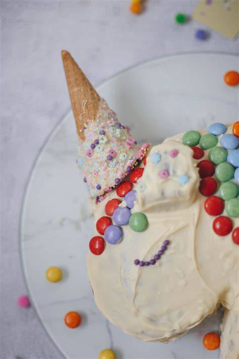 Einhorn-Torte fertig dekoriert mit Eiswaffel-Horn und bunten Details