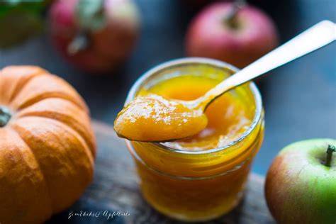 Einmachgläser mit Kürbis-Apfel-Marmelade und Zutaten