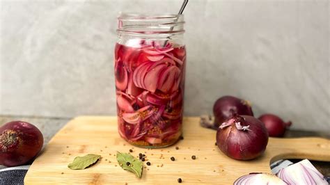 Einmachglas mit leuchtend rosa eingelegten roten Zwiebeln