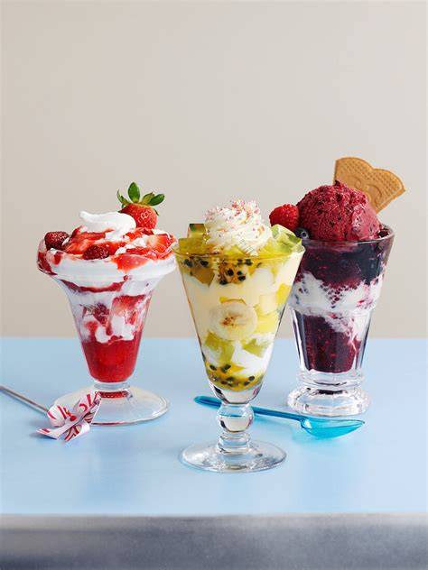 Eisbecher mit Vanilleeis und Cookie-Dough-Stücken, dazu Früchte