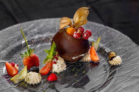 Eisbombe gestürzt auf Teller, dekoriert mit Sahnetuffs und Beeren