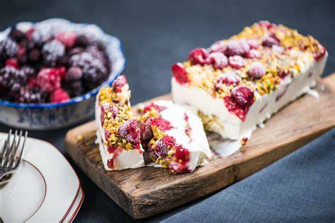 Eistorte im Anschnitt mit Beeren und Baiser
