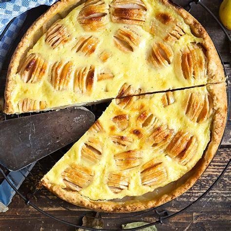 Elsässer Apfelkuchen mit eingeschnittenen Apfelvierteln auf mürbem Boden und Rahmguss