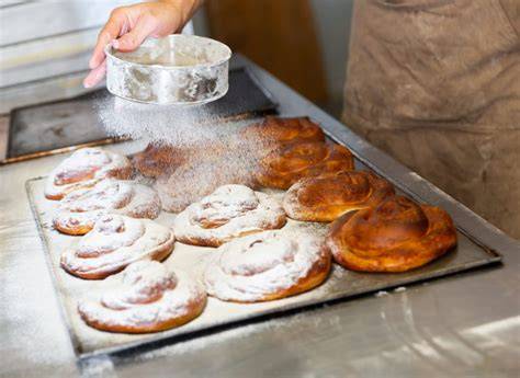 Ensaimadas auf einem Bäckertresen, mit Puderzucker bestäubt