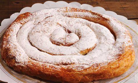 Ensaimadas auf einem mallorquinischen Bäckertisch, mit Puderzucker bestäubt