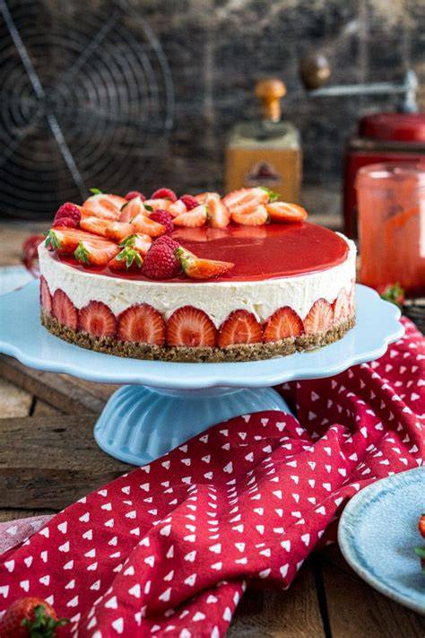 Erdbeer Nougat Torte angeschnitten, auf einer Tortenplatte, mit Erdbeeren dekoriert