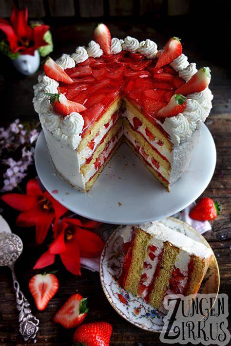 Erdbeer Vanille Torte, angeschnitten auf weißem Teller mit Sommerdekoration