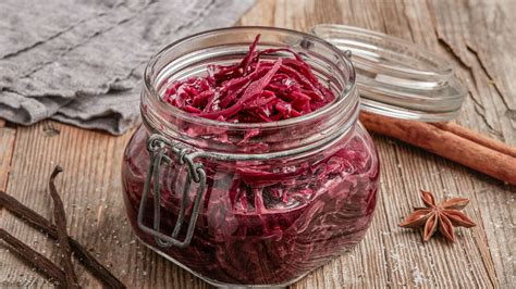 Erdbeer-Rhabarber-Marmelade im Glas, dazu Gewürze wie Vanille und Zimt