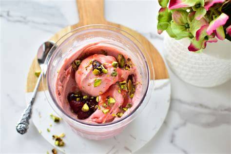 Erdbeereis mit Toppings Pistazien und Erdbeerscheiben in Schale