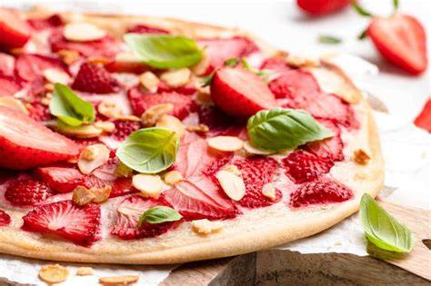 Erdbeeren mit frischem Basilikum auf Holzbrett