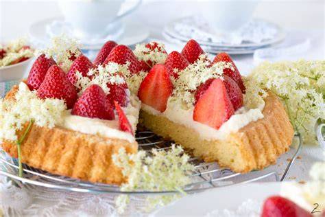 Erdbeerkuchen mit Holunderblütensirup und Zuckerguss dekoriert