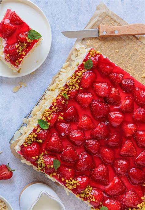 Erdbeerkuchen mit Vanillepudding dekoriert mit Minze und Mandeln