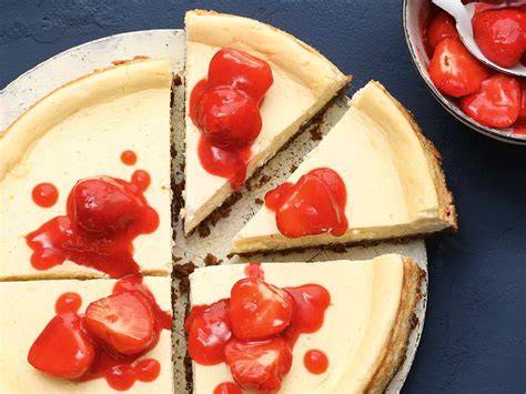 Erdbeersauce in Schale neben Cheesecake