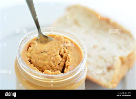 Erdnussbutter im Glas und auf Brot