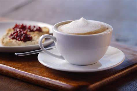 Espresso mit Schokoladenpulver und Milchschaum