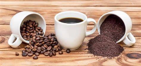 Espresso-Tassen auf einem Holztisch mit Schokoladenstängeln