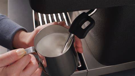Espressomaschine mit Dampfdüse beim Aufschäumen von Milch
