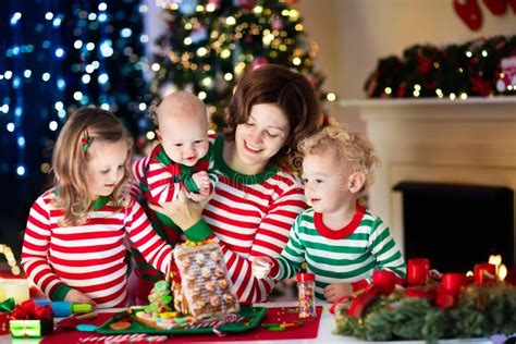 Familie beim Backen eines Lebkuchenhauses zu Weihnachten